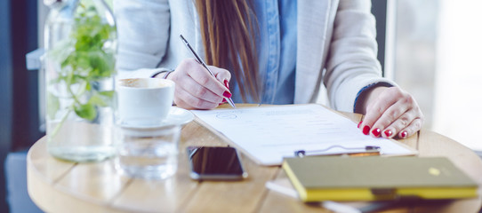 Unrecognizable Young Woman Sitting in Coffee Shop