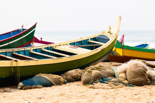Fishing colorful boats and nets on the beach.