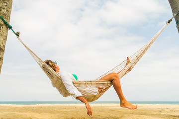 Woman relaxing at the beach on a hammock