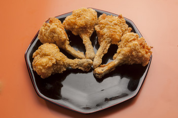 chicken lollypop on black plate