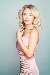 Naklejka premium Beauty Portrait of Perfect Blonde Fashion Model Woman with Curly Hair and Makeup Wearing Pink Bando Dress