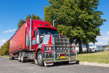 Vivid red semi truck parked in rural town, Australia