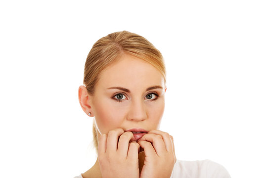 Stressed young woman biting nails
