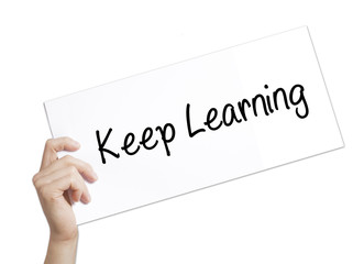 Keep Learning Sign on white paper. Man Hand Holding Paper with text. Isolated on white background