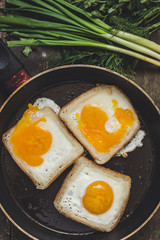 Fried eggs in bread and green lettuce leaf