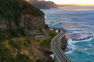 Aerial view of bridge along cliff edge and ocean