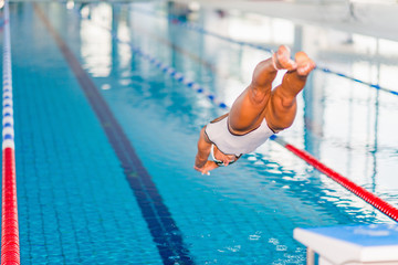 Female swimmer jumping in to the pool