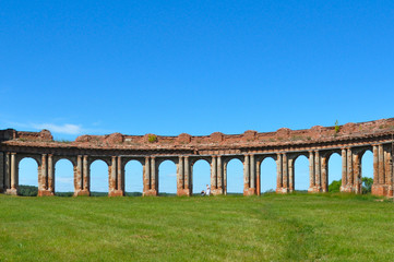 Fototapeta na wymiar Structured bricks colonnades with blue sky summer background