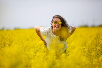 Young lovely brunette with sunglasses, in rapeseed
