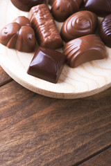 Candies in wooden bowl. Vertical shoot.