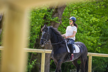 Lovely young brunette with sunglasses, riding a horse