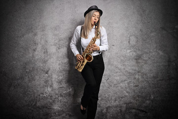 Attractive young woman playing a saxophone