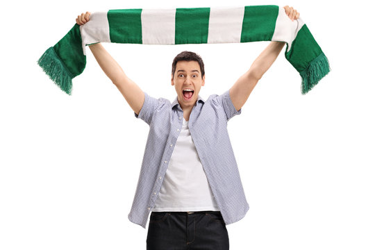Overjoyed football fan holding a scarf and cheering