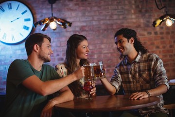 Young friends toasting beer mugs 