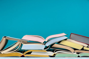 Open hardback colorful books on blue background. Back to school. Copy space for text. Education business concept.