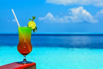 Glass of drink is on a beach table