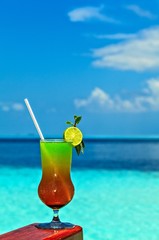 Glass of drink is on a beach table