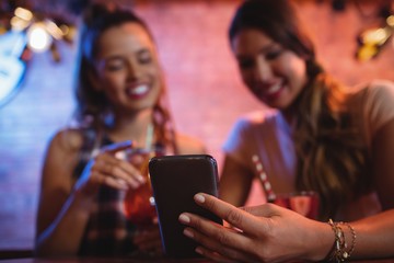 Two young women using mobile phone