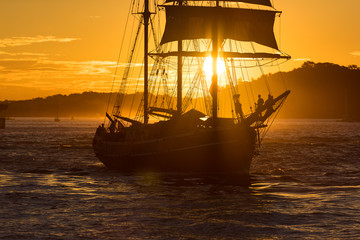 Naklejka na ściany i meble Sailing ship on colorful sunset