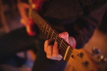 Fototapeta premium Mid-section of man playing guitar 