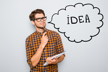 Photo of young thoughtful nerd in glasses thinking about new great idea, draw illustration