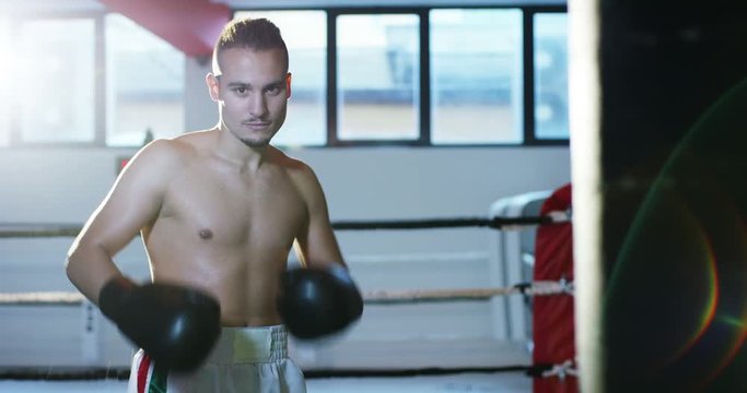 Portrait of a professional boxer in the gym, after coaching smiling and having fun, wearing black gloves, excellent body and preparation. Concept: love of sport, young boxers, love to win