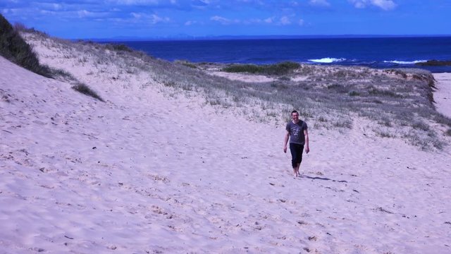 Boy running on the beach, then walks