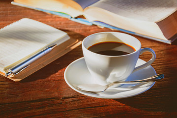Coffee mug and book on old wooden table