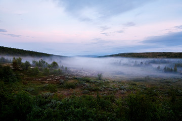 Fototapeta na wymiar road goes into the distance through the hills through the fog. Concept travel around Russia. Teriberka, Kola Peninsula, Russia.