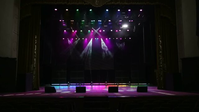 Illumination of a stage during a concert. Several projectors in the dark.