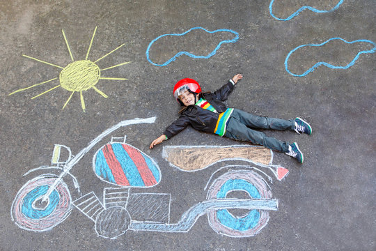 Little kid boy in helmet with motorcycle chalk picture 