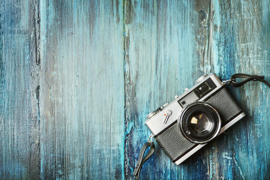 Vintage photo camera on grunge wooden background