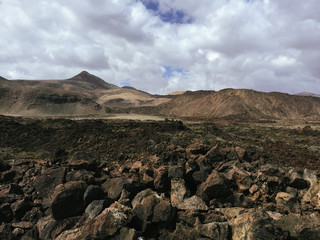 Beautiful view overlooking rusty red desert, distant mountains in Fuerteventura island, Canaries, Spain