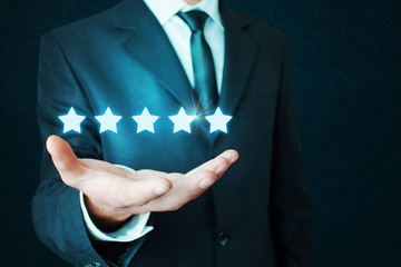Businessman holding five stars.