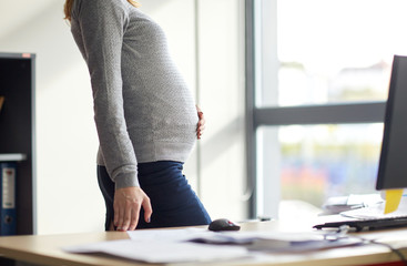 pregnant businesswoman with computer at office