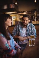 Couple interacting while having beer at counter