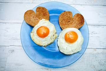 Fried eggs with toast in heart shape