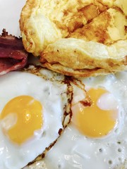 Low carb breakfast with omelette, fried eggs and bacon