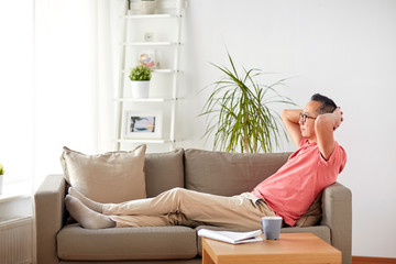 man in glasses relaxing on sofa at home