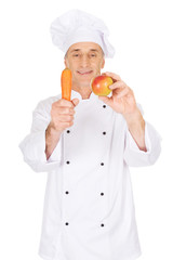 Male chef with an apple and carrot