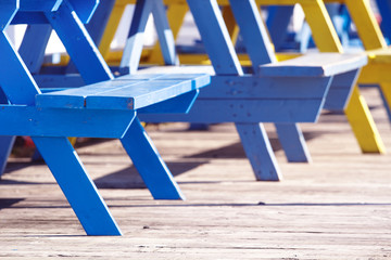 Detail view of picnic table seats in bright sunshine