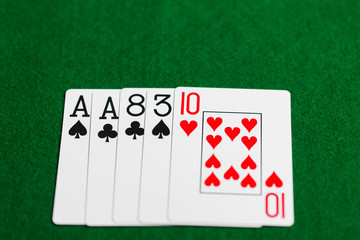 poker hand of playing cards on green casino cloth