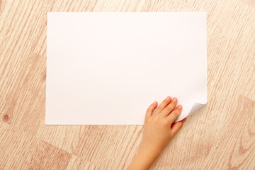 Fototapeta premium Child's hand turning over paper