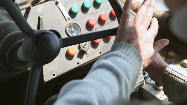 Close-up of hands turning the steering wheel of an old bulldozer (tractor)