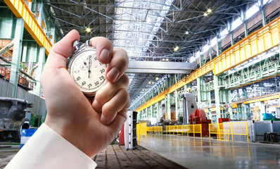 Machine shop and stopwatch in male hand