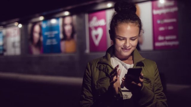 Women using smart phone while walking in the city at nigth. Urban people lifestyle background.