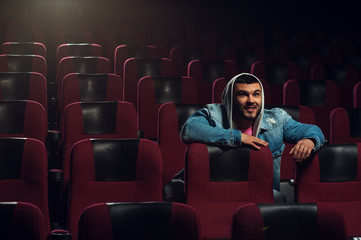 Happy excited young man watching movie in theater