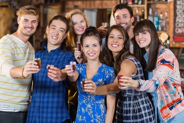 Portrait of happy friends holding short glasses