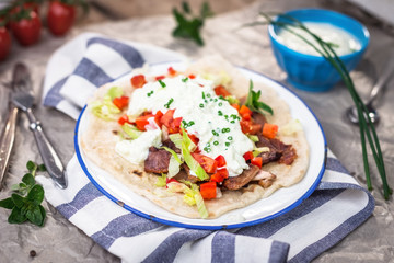 Gyros with vegetable, meat and tzatziki sauce