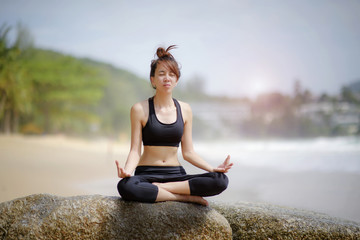 Fototapeta premium young woman yoga practice on the beach at sun shade